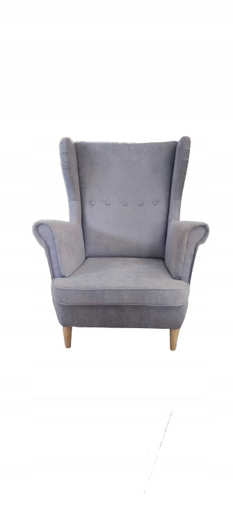 Ujęcie na fotel uszak w stylu skandynawskim z pięcioma guzikami oraz drewnianymi nóżkami. Fotel uszak do salonu posiada wygodne podłokietniki.