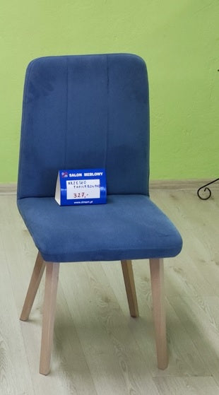 Niebieskie krzesło tapicerowane wyprzedażowe na drewnianych jasnych nogach to elegancki mebel do wielu pomieszczeń.
