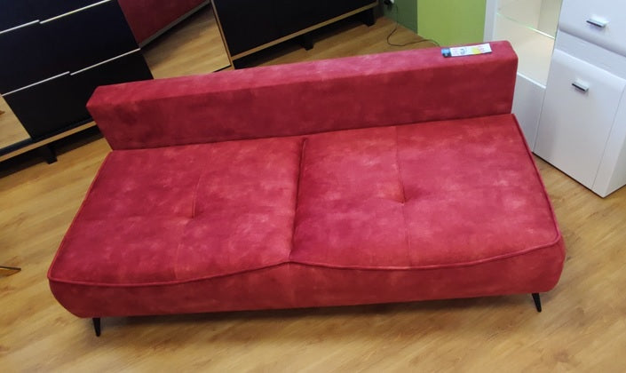 Ujęcie z przodu na kanapę rozkładaną VELA bez poduch i boczków ukazuje głębokie siedzisko, które może stanowić powierzchnię spania dla jednej osoby bez rozkładania mebla.