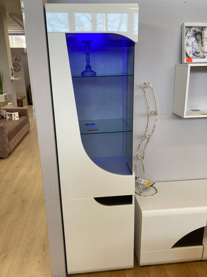 Witryna BRYZA biała front z ozdobnym szkłem niebieskie oświetlenie LED to elegancki mebel z czarnymi wnękami służącymi jako uchwyty.