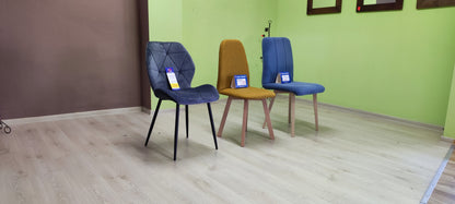 Ujęcie z boku na niebieskie krzesło tapicerowane oraz inne krzesła wyprzedażowe.