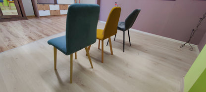 Ujęcie z boku na niebieskie krzesło tapicerowane oraz inne krzesła wyprzedażowe.