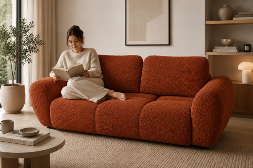 Na zdjęciu prezentuje się pikowana sofa idealna do wypoczynku Agnello 2 Ruda Boucle